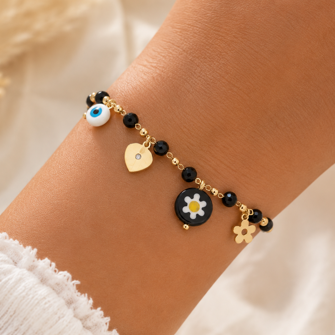 Bracelet en acier inoxydable doré avec perles noires, marguerite, cœur, fleur et œil porte-bonheur.