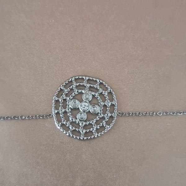 Bracelet argenté raffiné avec pendentif rond finement travaillé en spirale, bijou élégant pour un style chic et discret