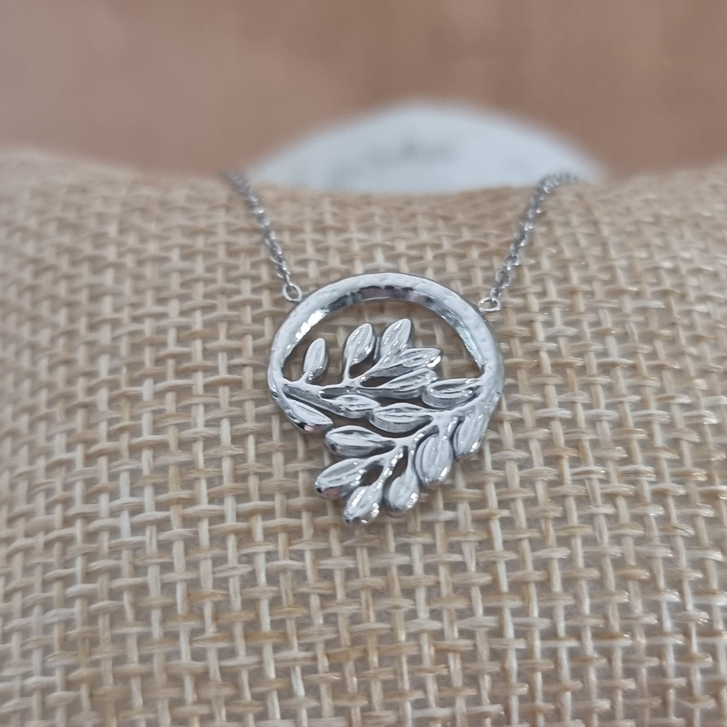 Collier argenté pendentif cercle orné de feuilles minimalistes
