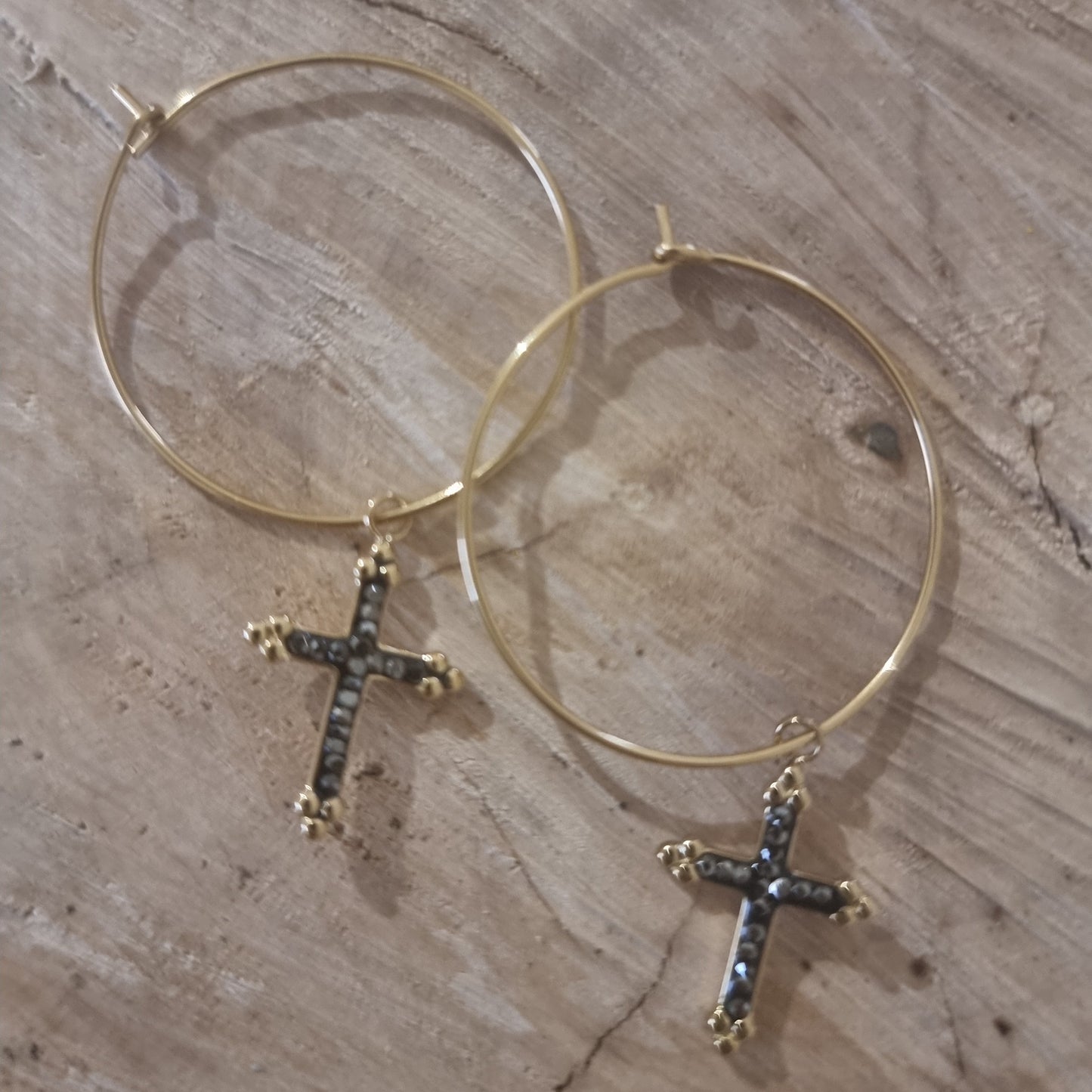 Détail du pendentif croix strass noir et doré sur créoles