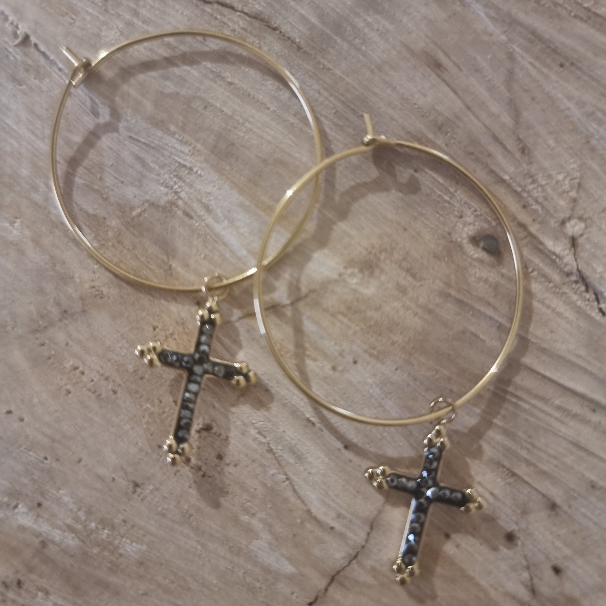 Détail du pendentif croix strass noir et doré sur créoles