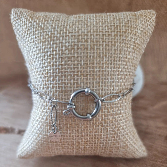 Bracelet argenté avec anneau marin central et chaîne fine.