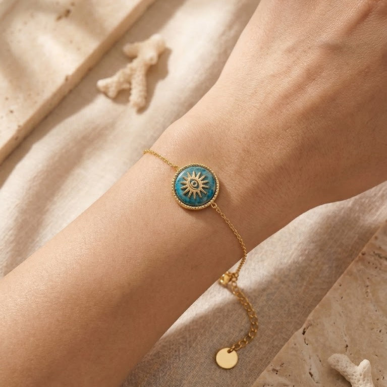 Bracelet Athena en acier inoxydable doré porté au poignet avec médaillon œil vert bouteille - MissZa