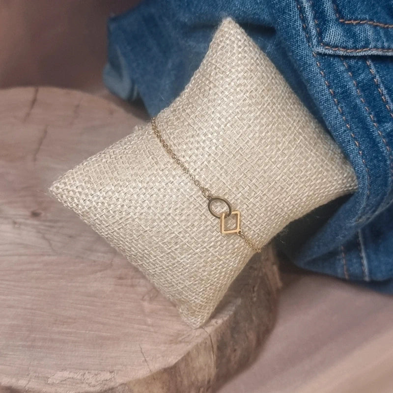 Détails d’un bracelet doré géométrique avec formes rond et losange entrelacées