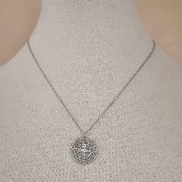 Collier argenté avec pendentif rond ajouré vu sur buste.