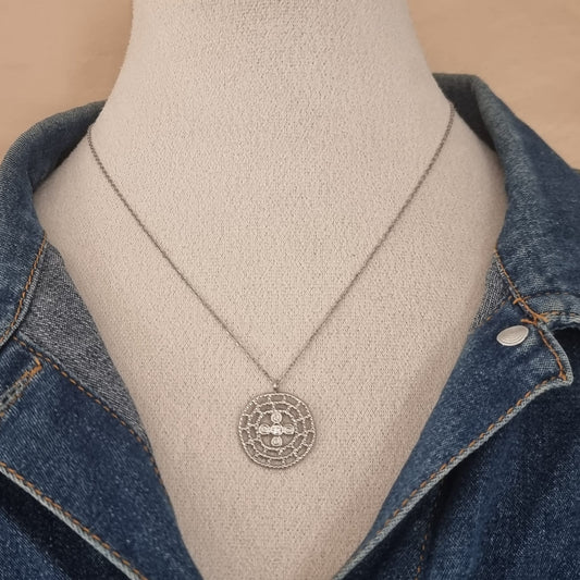 Collier argenté porté sur buste avec veste en jean.