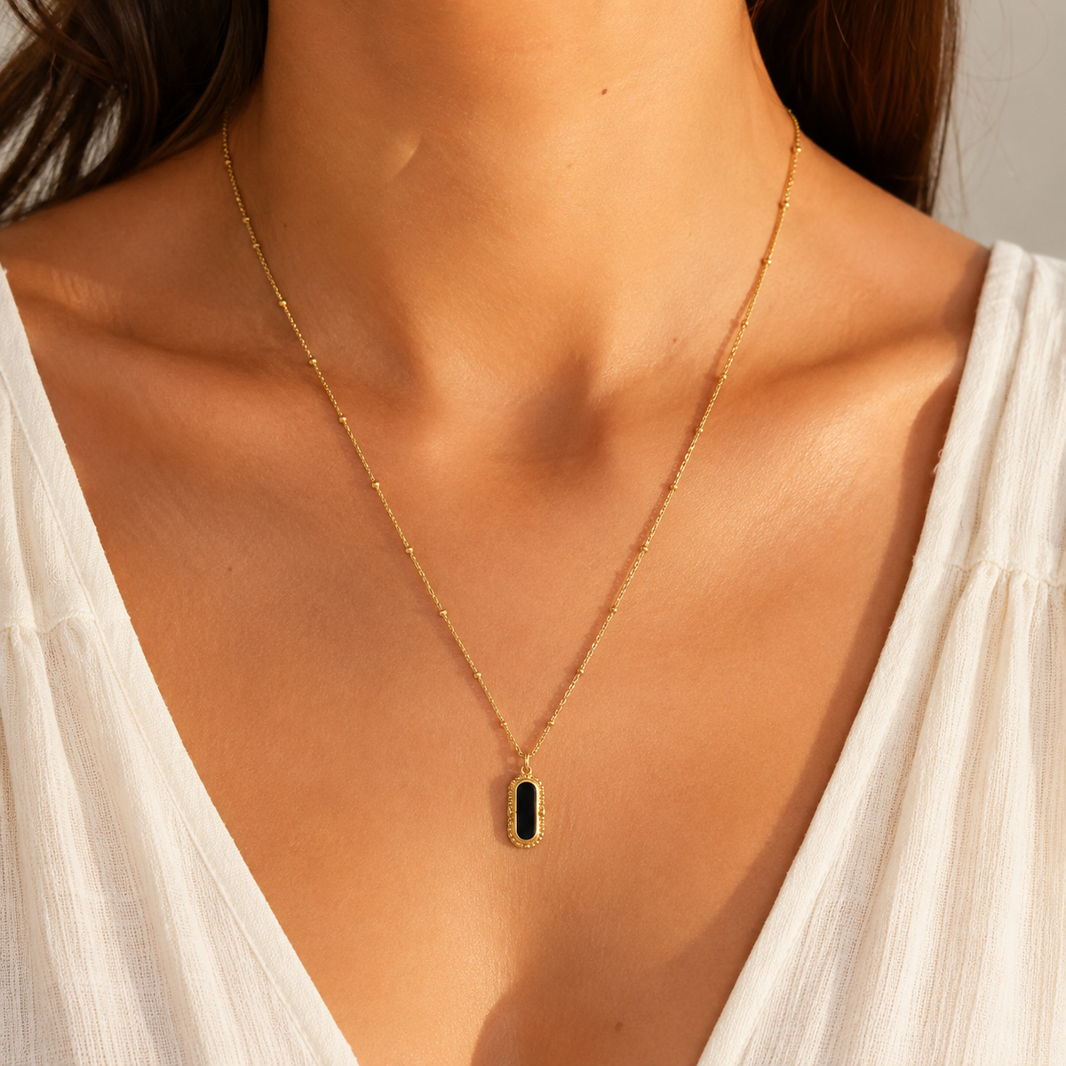 Collier LILOU porté sur un mannequin avec pendentif noir en acier inoxydable doré - MissZa