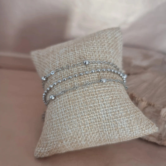 Trio de bracelets "Aurore" en acier inoxydable, composé d’un bracelet à mailles fines, d’un modèle à petites perles et d’un design contemporain, vue rapprochée